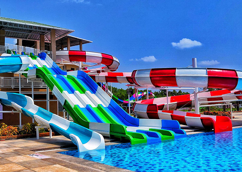 Striped water slides running down into a blue pool